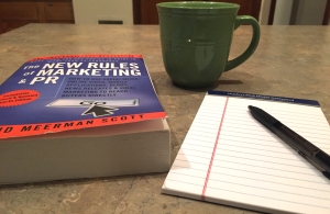 A copy of The New Rules of Marketing and PR by a notepad and cup of coffee